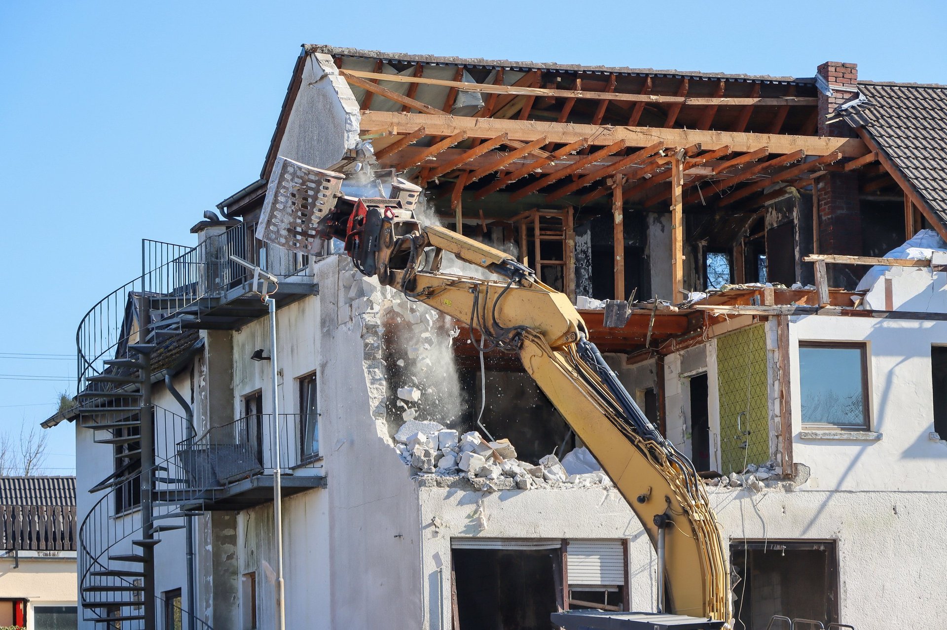 Excavator demolishing home
